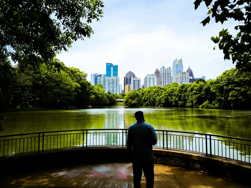 a man standing on a bridge looking at the water — Atlanta