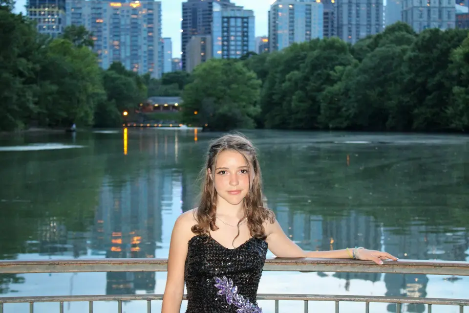 a girl in a black dress standing on a bridge — Atlanta
