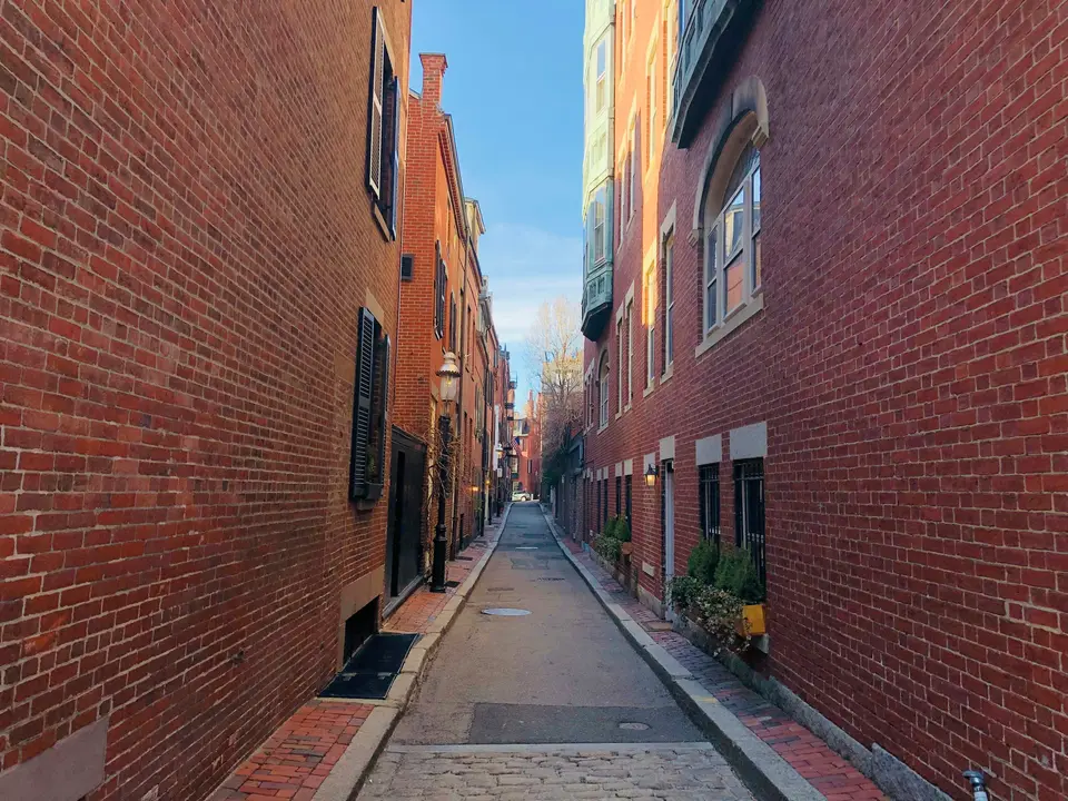 empty pavement in between brick building during daytime — Boston