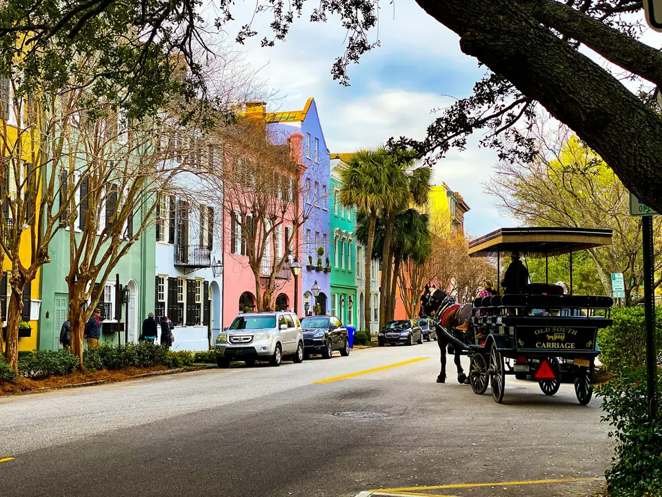 people riding on carriage on road during daytime — Charleston