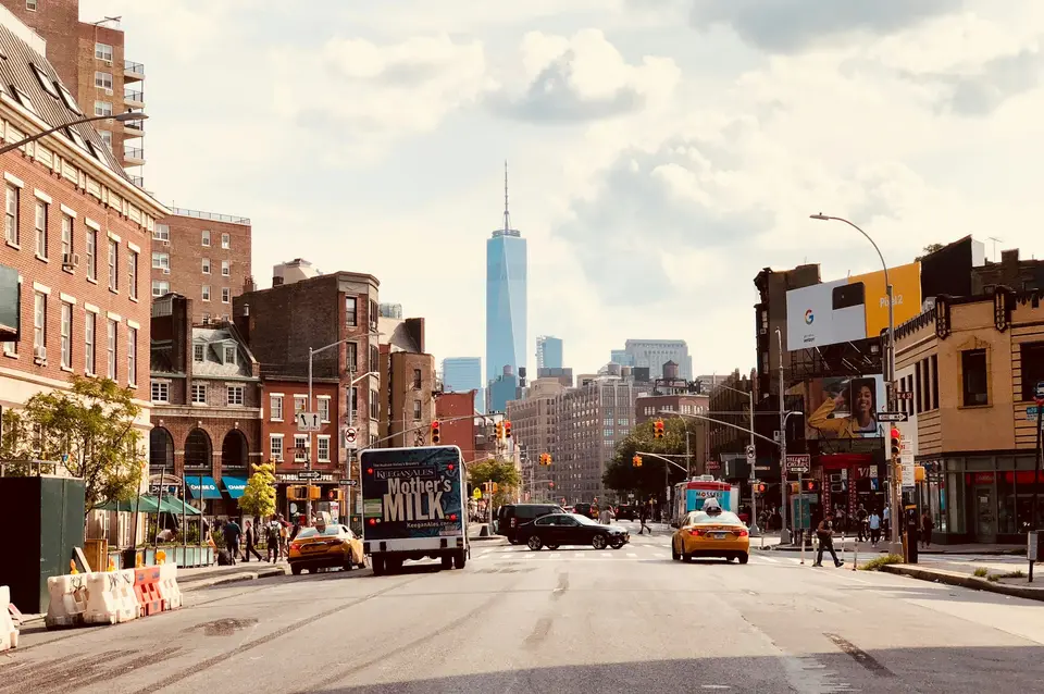 cars parked on side of the road near high rise buildings during daytime — New York