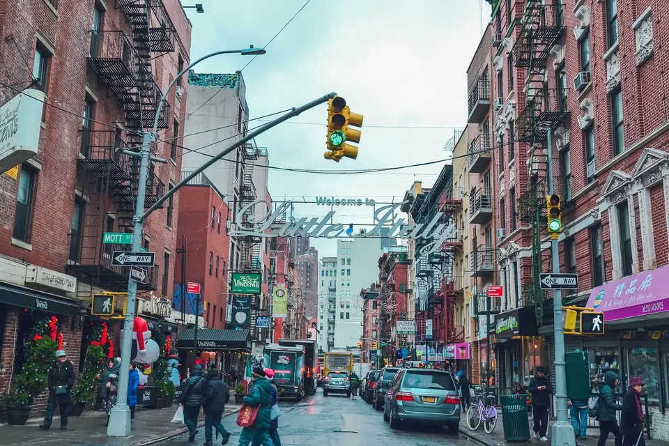people walking by the street with parked cars on side — New York