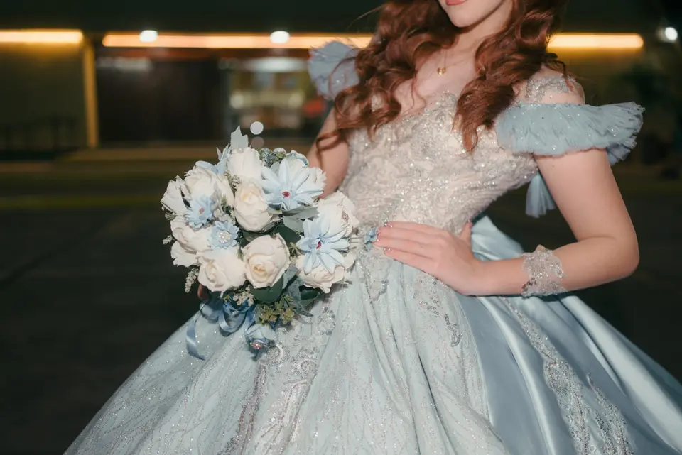 Woman in a light blue ball gown holding a bouquet