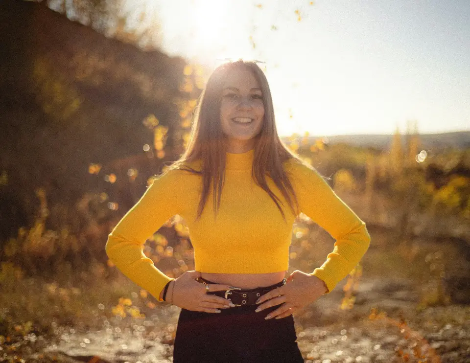 a woman in a yellow shirt posing for a picture